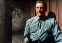 Sheriff Matt Morgan (Kirk Douglas) steht in einer Tür und hält eine Pistole in der Hand.