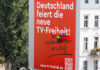 "Deutschland feiert die neue TV-Freiheit" Plakat an Häuserfassade