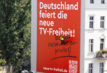 "Deutschland feiert die neue TV-Freiheit" Plakat an Häuserfassade