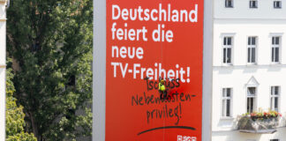 "Deutschland feiert die neue TV-Freiheit" Plakat an Häuserfassade