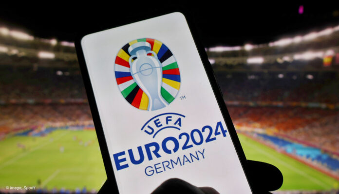 Smartphone mit EURO 2024 Logo im Fußballstadion