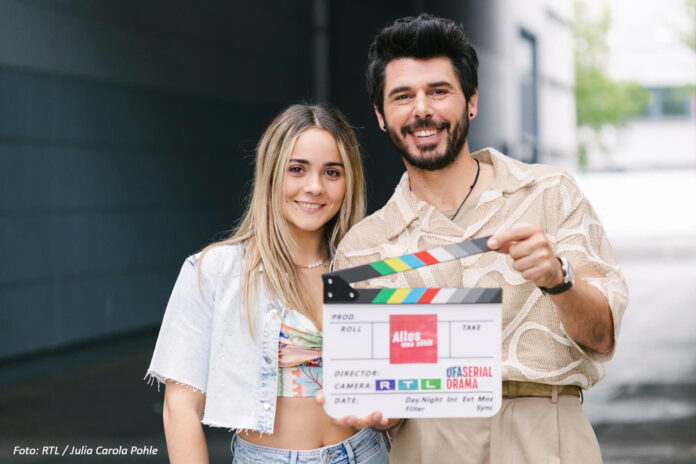 Antonia Kolano und Riccardo Angelini halten eine Filmklappe in der Hand