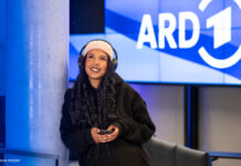 Frau mit Kopfhörern unter dem ARD Logo