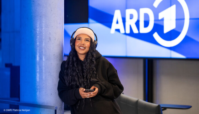 Frau mit Kopfhörern unter dem ARD Logo