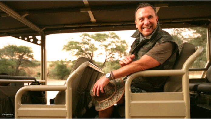 Szene aus "Herr Raue reist! So schmeckt die Welt" bei MagentaTV+: Tim Raue sitzt in einem Jeep in Namibia.