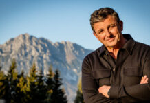 Schauspieler Hans Sigl steht vor einem Bergpanorama