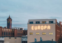 Ein Leuchtschriftzug "EUROPA" auf der Fassade eines Hauses.