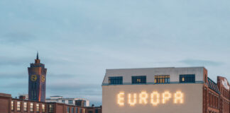 Ein Leuchtschriftzug "EUROPA" auf der Fassade eines Hauses.