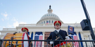 Zwei Trommler in Uniform, die vor dem US-amerikanischen Kapitol trommeln, aus der Froschperspektive aufgenommen.