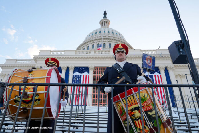 Zwei Trommler in Uniform, die vor dem US-amerikanischen Kapitol trommeln, aus der Froschperspektive aufgenommen.