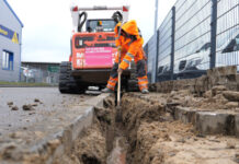 Glasfaser-Ausbau: Ein Bauarbeiter gräbt eine Mulde für Telekom-Glasfaserkabel.