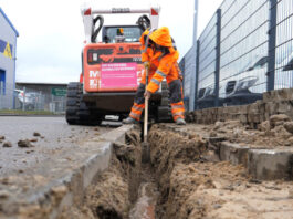 Glasfaser-Ausbau: Ein Bauarbeiter gräbt eine Mulde für Telekom-Glasfaserkabel.